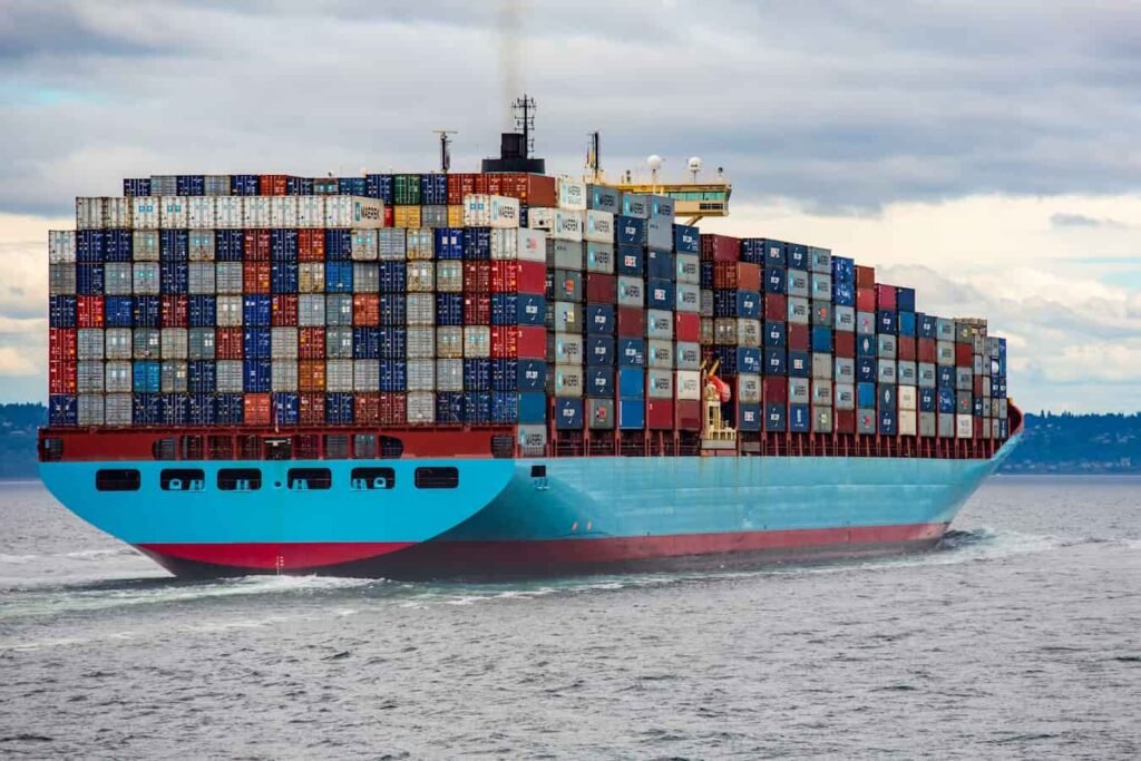 Ouvriers en gilets de sécurité triant des oranges sur un tapis roulant industriel