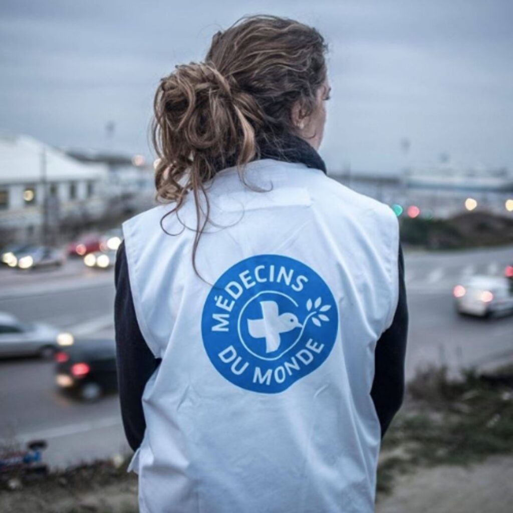 Médecins du Monde attaque l’État : l’ouverture de nouvelles « salles de shoot » bloquée Une femme portant une veste qui arbore le logo "Médecins du monde"
