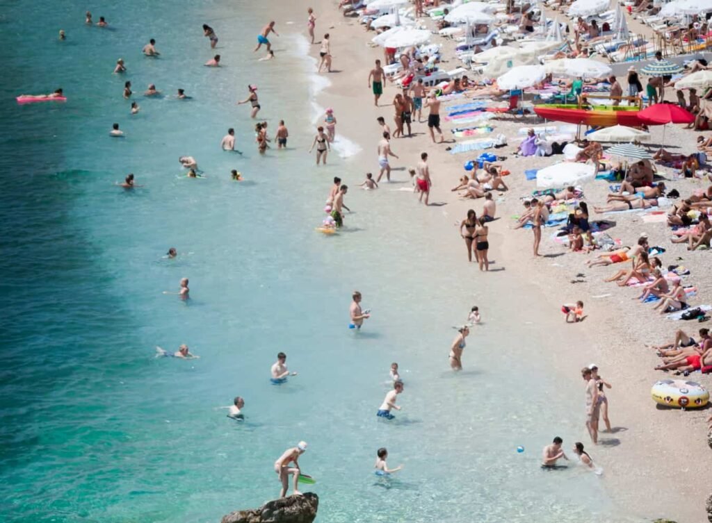 Plage de sable des Chalets à Gruissan avec mer calme et plateforme flottante au large