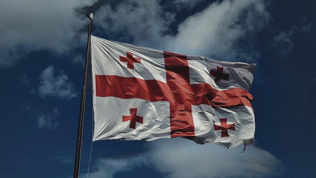 L’Europe met en garde la Russie contre une annexion formelle de l’Ossétie du Sud Quatre drapeaux nationaux alignés devant un bâtiment institutionnel